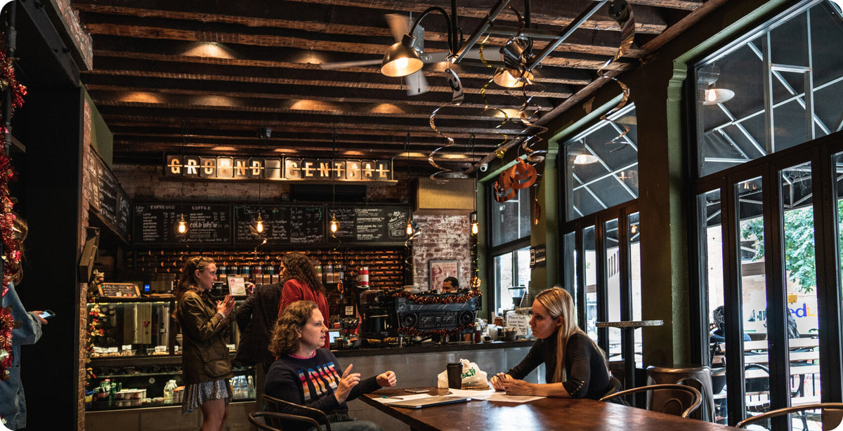 Guests at the tables inside a Ground Central coffee shop