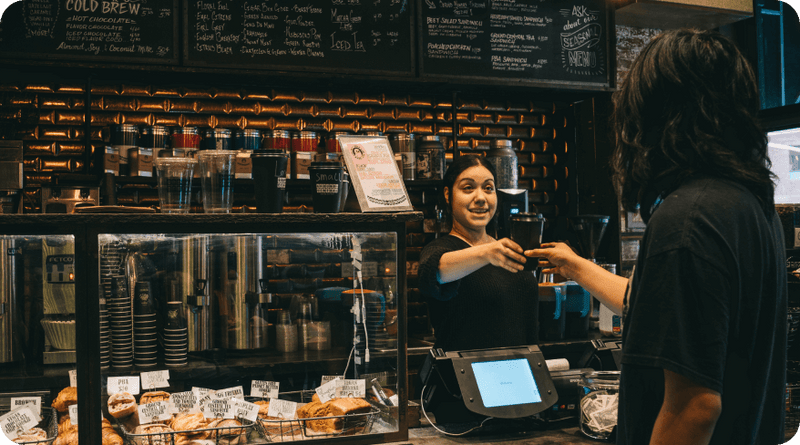 Ground Central barista serving a customer at the pastry counter