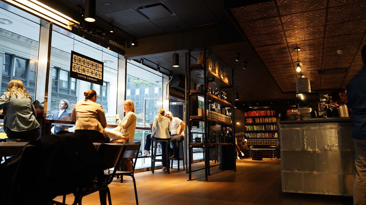 Customers at high tables by the windows at GC Little Brazil
