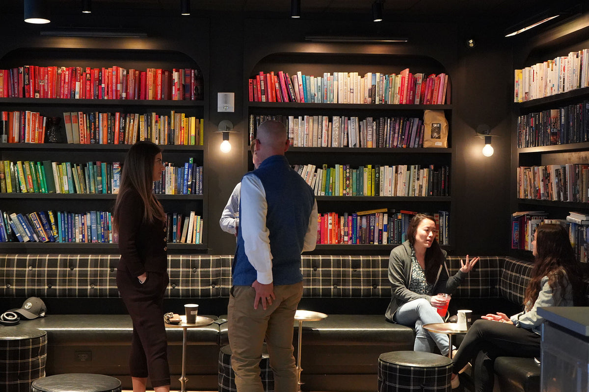 Customers browsing the bookshelf wall at GC Little Brazil
