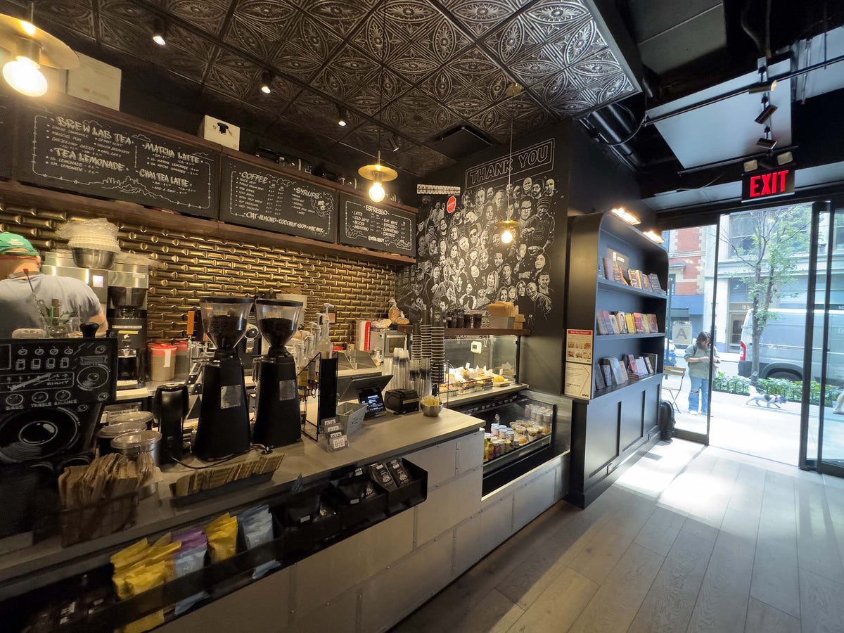 Espresso counter with brick wall and pressed-tin ceiling at GC Madison Square Park
