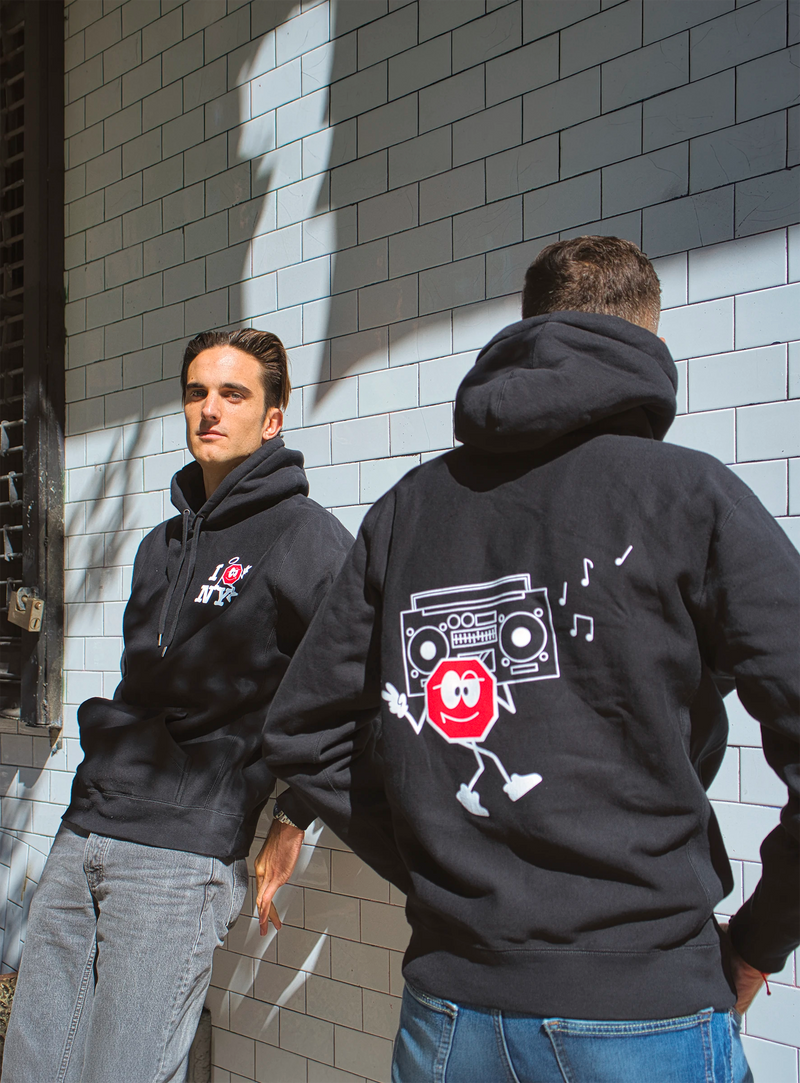 Two people wearing Ground Central hoodies, the I Love NY design and the Boombox design on the back