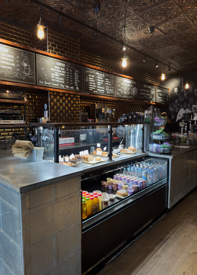 Inside a Ground Central café in New York: pastry case, chalkboard menus and pressed-tin ceiling