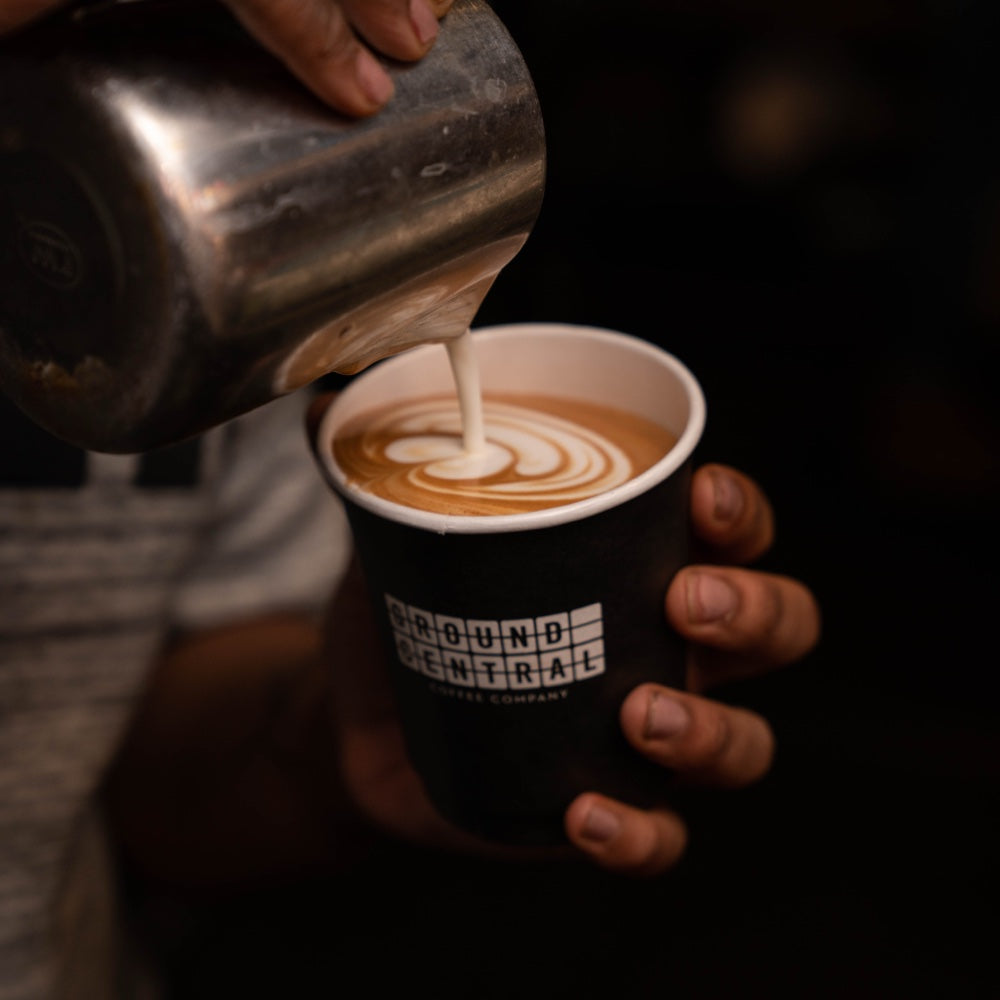 Latte art being poured into a cup